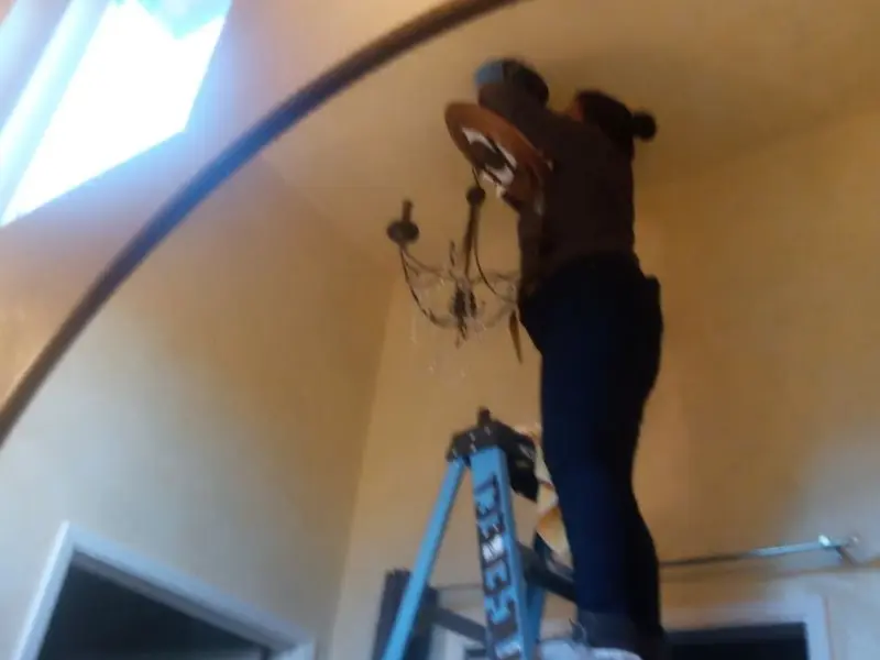 Electrician installing a chandelier in a St. James City residence